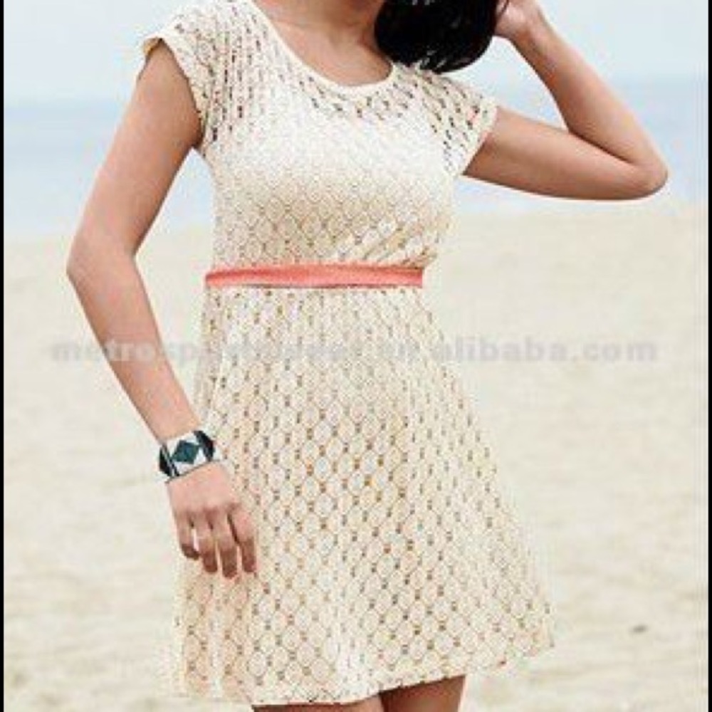 Tan crochet, knit dress with coral ribbon.